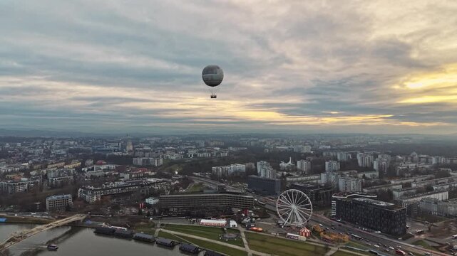 Hot Air Balloon Soaring Over Krakow Cityscape at Sunset