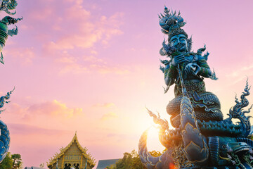 Fototapeta premium Wat Rong Suea Ten, Blue temple complex at sunset glow Chiang Rai, Thailand with sunlight