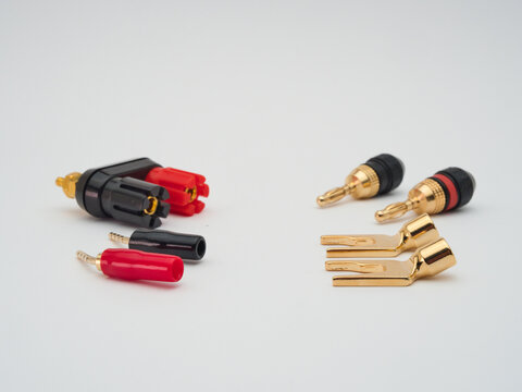 Audio Connectors and Adapters Assortment - A variety of gold-plated audio connectors, including banana plugs, spade connectors, and binding posts, displayed on a clean white backgroun