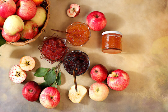 Fresh apple butter or jam made from various apple varieties. An assortment of preserves, fruit butters and fresh fruit purees arranged on a concrete kitchen counter.home canning concept, banner