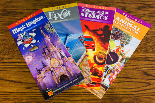 Mid-2000s Disney World brochures for Magic Kingdom, Epcot, MGM Studios, and Animal Kingdom on a desk, Sedalia, Missouri, June 2025