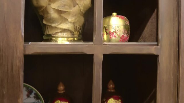 The large glass jar on a shelf contains dried bird's nest highly valued delicacies in traditional Vietnamese and Chinese cuisines and medicine and a smaller, ornate container next to it is decorated 