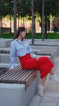 Woman enjoying a quiet outdoor break on a courtyard bench, embracing personal time, everyday relaxation and a slower urban rhythm