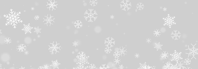 Falling snowflakes create a serene winter scene against a dark backdrop. Various sizes and subtle glowing orbs add depth and contrast. This image is ideal for seasonal greetings and festive. © kleinstock