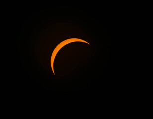 A thin orange crescent moon glows against the dark night sky. © Kit Leong