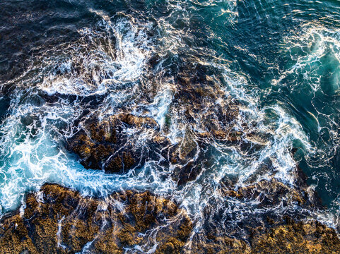 Waves hitting coastline. Blue ocean waves. Tropical coastline waves. Strong wave movement. Waves along dramatic coastline.