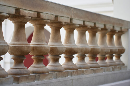 Close view of stone balustrade with repeating shaped balusters inside historic building