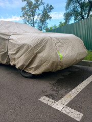 Nylon car cover protecting parked vehicle in residential yard shielding from dust rain and sunlight © Harmony Video Pro