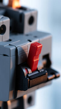Electrical component concept gray motor starter overload relay with a red test button close up product detail bright clean studio background soft even lighting industrial