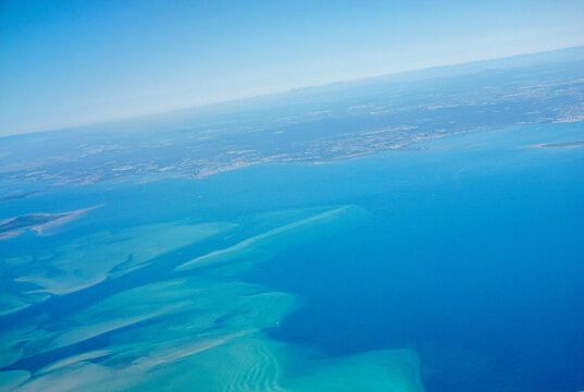 Tilted horizon over habour shallow water and coastal city in blue hues for conceptual of background use.