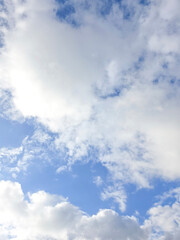 Fototapeta premium Blue Sky with White Clouds Nature Background. Beautiful Outdoor Landscape with Fluffy Cloudscape, Blue Atmosphere, Fresh Weather, Peaceful Nature Scene. Scenic Sky Photo for Travel, Summer. Vertical.