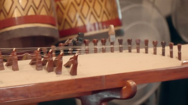 Woman in red playing on 16-stringed Dan Tranh (gayageum, kayagum) - traditional Vietnamese musical&nbsp;instrument