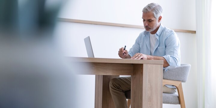 40s business man company manager investor working on computer writing notes