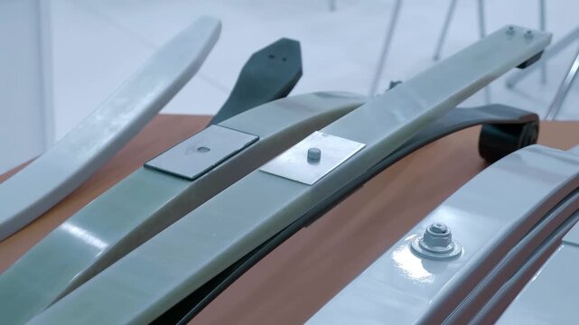 Composite leaf springs are elastic suspension components made from fiber-reinforced polymer materials. Closeup. Shot in motion