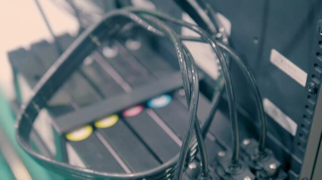 A row of multiple cartridges of different colors from a large industrial printer. Closeup. Shot in motion