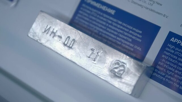 A bar made of chemically pure indium with data engraved on it. Closeup. Shot in motion. Follow focus