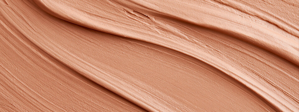 Liquid foundation cream texture with diagonal ridges. Nude beige cosmetic lotion swatch