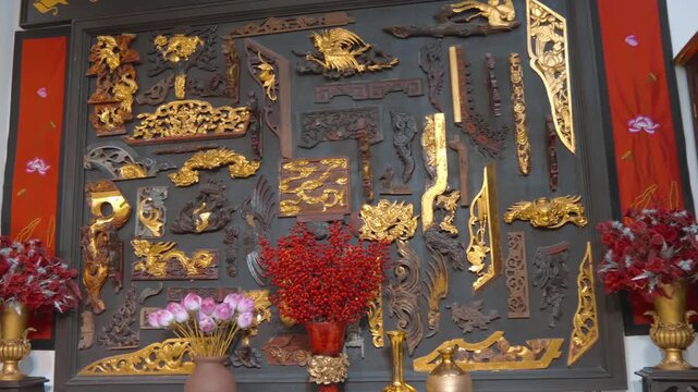 intricately carved and gilded traditional wooden art pieces, reminiscent of Vietnamese Son Dong sculpture with various decorative motifs and architectural elements often found in Asian temples or dedi