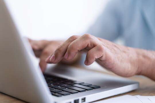 Man hands typing on computer keyboard closeup, businessman using laptop at office