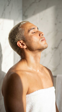 Serene young man tilting head back with eyes closed during morning ritual