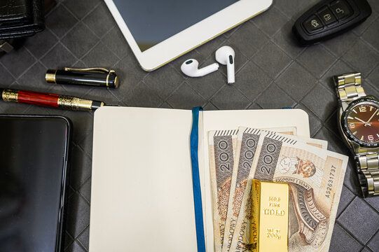Close up of Men Wrist Watch Resting on Gold Bar and 200 Polish Zloty Money Bills Frame