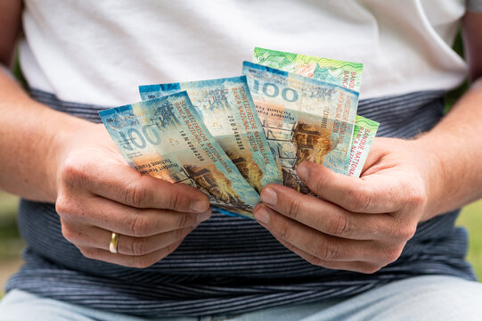 Male Hands Holding and Counting Stack of Swiss Francs Banknotes for Business Finance Concept