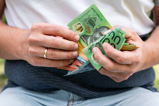 Male Hands Holding and Counting Stack of Australian Dollar Bills for Business Finance Concept