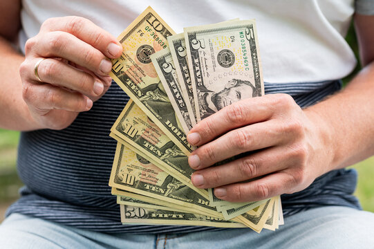 Close up of Man Hands Holding Fan of American Dollar Bills for Global Economy and Savings Concept