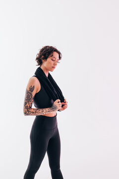 Confident sportswoman with towel resting in studio