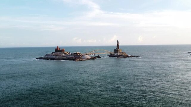 Elevated Aerial View of Vivekananda Rock Memorial and Thiruvalluvar Statue in Kanyakumari. Coastal Rock Island Memorials Surrounded by Rippling Indian Ocean Waves.