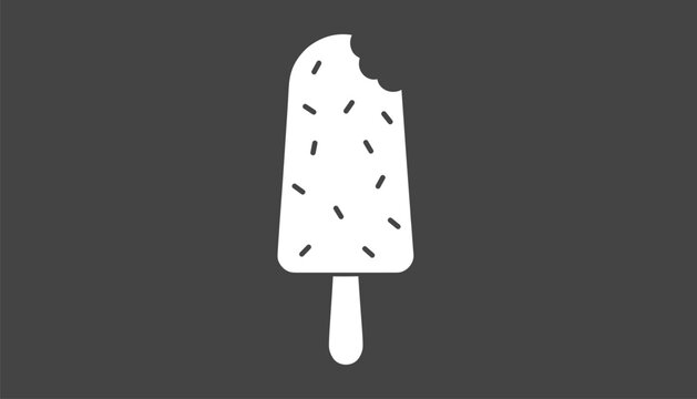 Delicious frozen ice cream popsicle on a wooden stick covered in colorful candy sprinkles with a bite taken out against a dark backdrop.