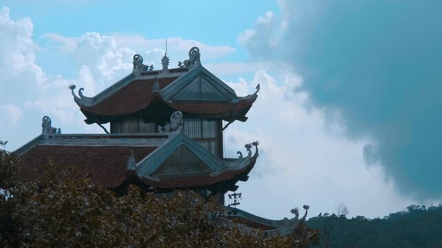 Traditional Vietnamese multi-tiered tiled roofs of the Pagoda built in classic Northern Buddhist architectural style with intricate tiled roof curves, ornate ridge decorations, and dark silhouettes se