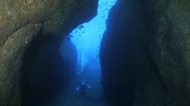 cave diving underwater scuba divers exploring caves and having fun ocean scenery sun beams and rays background