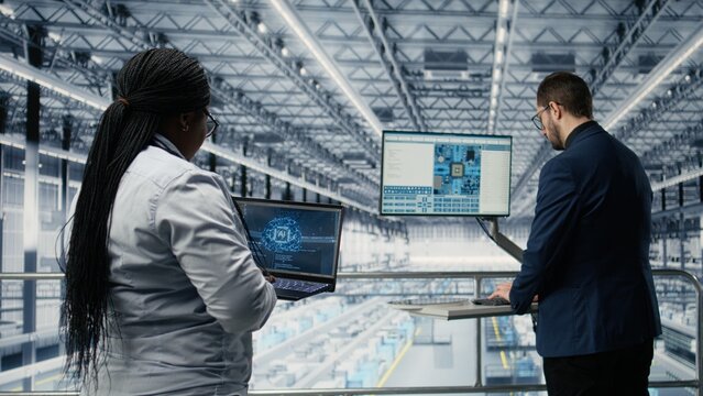 Woman and colleague use AI to develop an innovative microchip factory roadmap, applying artificial intelligence and high tech engineering while developing semiconductors in the smart factory.