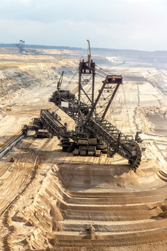 Bucket-wheel excavator mining brown coal in a large open-pit mine. The massive mining machine is used for surface extraction of lignite.