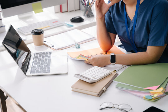 Office Desk Detail: A close-up shot captures the focused concentration of a person working at their office desk, surrounded by essential tools of productivity.