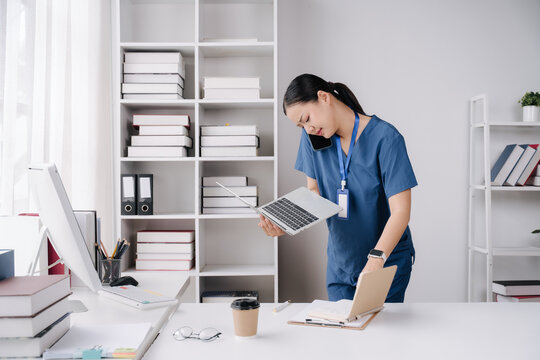 Busy Healthcare Professional: A focused healthcare worker juggles multiple tasks, talking on the phone, holding a laptop, and reviewing a chart in an organized office setting.