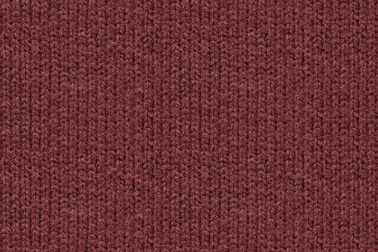 A full-frame, detailed close-up shot of wine red color knitted wool fabric texture. Characteristic vertical ribbed knit pattern and soft yarn fibers. Top down view