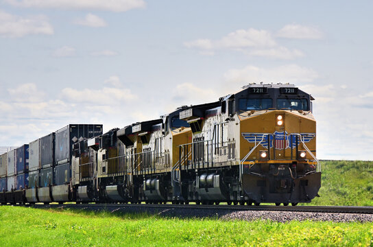 Multiple locomotives lead a westbound Union Pacific stack train through a rural stretch of land in north central Illinois.