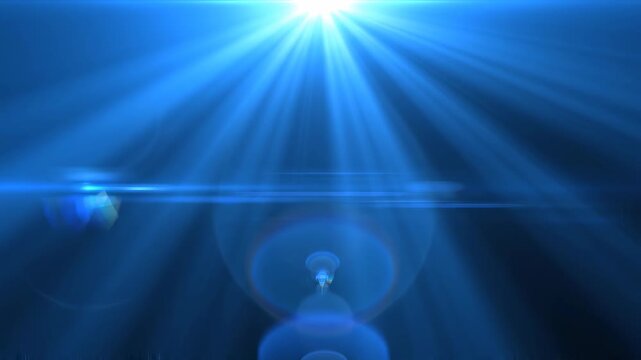 Radiant blue light beams emanating from a central point with lens flares during a cinematic reveal