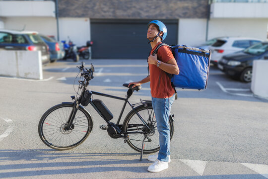 Delivery courier with electric bike at delivery destination