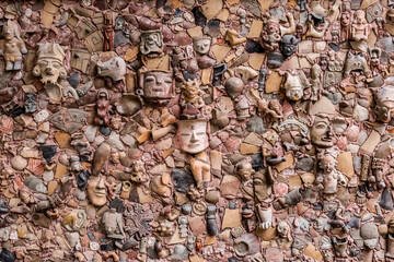 Wall composed of ceramic fragments and pre-Columbian masks  wall at the Simón Bolívar Andean University, Ecuador. January 8, 2025. A mural constructed from hundreds of pre-Columbian ceramic fragments. © SandraMilena