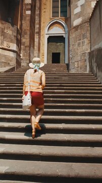 A female tourist enters the Cathedral of Santa Maria Assunta in Naples