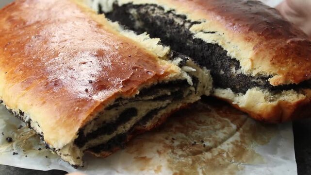 Golden brown baked pastry with rich poppy seed filling, sliced open to reveal spiral pattern.