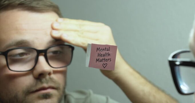 Stressed man looking at himself in the mirror with a &ldquo;Mental Health Matters&rdquo; sticky note, concept of mental health awareness, emotional stress, self-reflection and wellbeing.