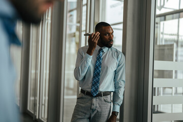African american businessman listening to smartphone voice message