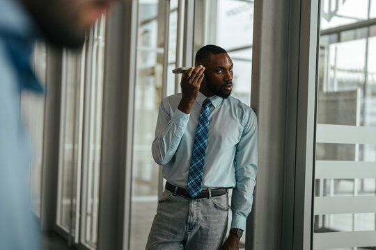 African american businessman listening to smartphone voice message