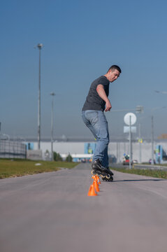 A Caucasian man rollerblades around the slalom course.