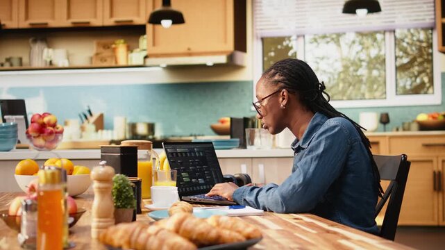 Woman focused on programming and software development tasks. Laptop screen displays code, scripts and binary data, illustrating system maintenance and remote work in high-tech occupation.