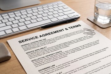 Obraz premium Service Agreement Document on Wooden Desk with Keyboard